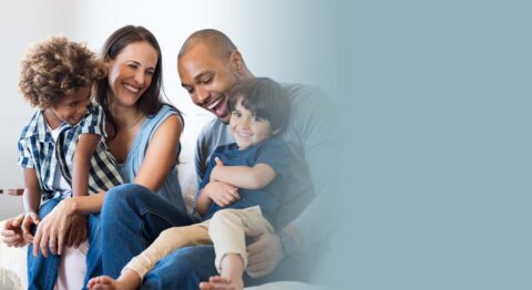 Smiling family of four on sofa